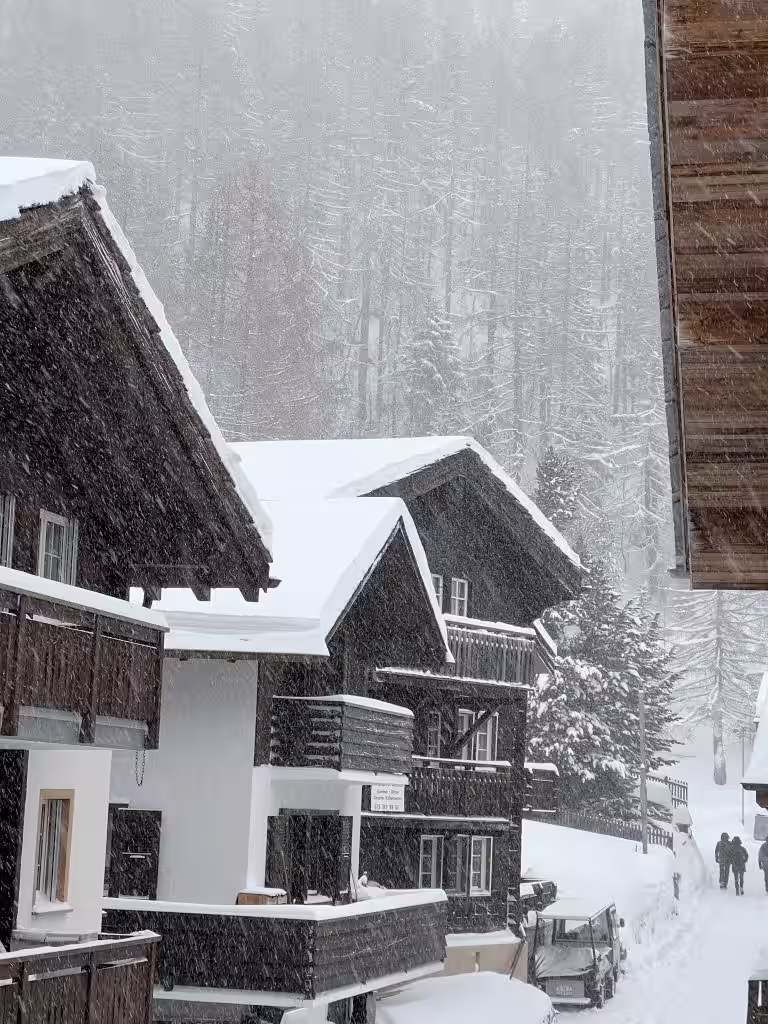 Des chalets en montagne pendant qu'il neige
